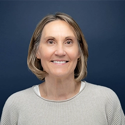 JoAnn Kinitzel smiles into the camera against a dark blue background.
